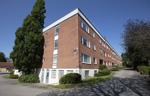 Bild på trevåningshus i tegel
