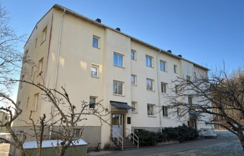 Ett gult trevåningshus med två trappuppgångar